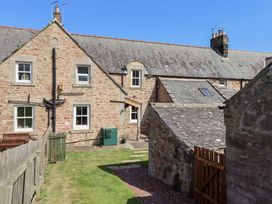 An outdoor view of a stone house and garden at Bruno's Bothy in Middleton near Belford