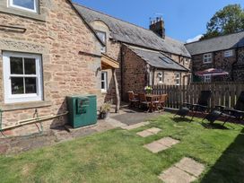 An outdoor area with seating and garden space at Bruno's Bothy Middleton near Belford