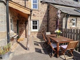 An outdoor seating area with a table and chairs at Bruno's Bothy Middleton near Belford