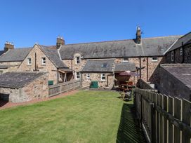 A garden area with cottages and outdoor furniture at Kits Cottage Middleton near Belford