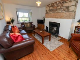 A living room with a fireplace and sofa at Kits Cottage Middleton near Belford
