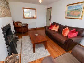 A living room with furniture and a fireplace at Kits Cottage Middleton near Belford