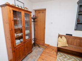 A dining room with a cabinet and bench at Kits Cottage Middleton near Belford