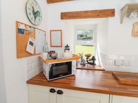 A kitchen with a microwave and kettle at Kits Cottage Middleton near Belford