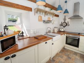 A kitchen with a sink and microwave at Kits Cottage in Middleton near Belford