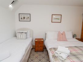 A bedroom with two beds and nightstands at Kits Cottage in Middleton near Belford