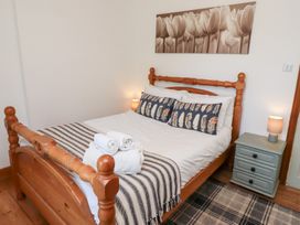 A bedroom with a bed and side table at Kits Cottage Middleton near Belford