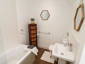 A bathroom with a bathtub, toilet, and sink at Kits Cottage in Middleton near Belford