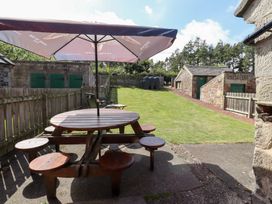 A garden with a picnic table and shed at Kits Cottage in Middleton near Belford