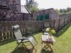 A garden with deck chairs and a table at Kits Cottage Middleton near Belford