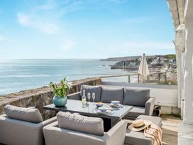 An outdoor seating area with a table and chairs at Loe Cottage in Porthleven