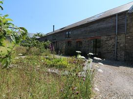 An outdoor view of a building with a garden at The Milking Shed in Bantham