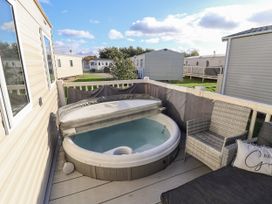 A hot tub and outdoor seating on a deck surrounded by mobile homes at HD Retreat in Tattershall