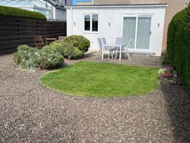 A garden with grass and a patio set at Maywood in Seahouses