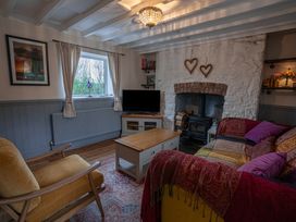 A living room with a wood stove fireplace a television armchair and sofa at Rivendell in Ffynnongroyw