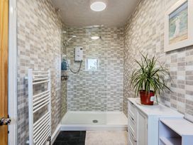A bathroom with a shower and plant at Rivendell in Ffynnongroyw
