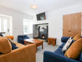A living room with a fireplace and television at Trefor Ganol Beaumaris