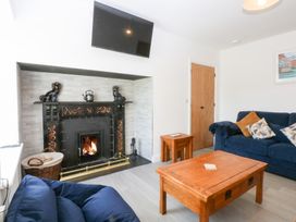 A living room with a fireplace and sofa at Trefor Ganol Beaumaris
