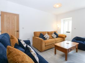 A living room with a sofa and armchair at Trefor Ganol Beaumaris