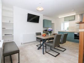 A kitchen with dining table and chairs at Trefor Ganol Beaumaris