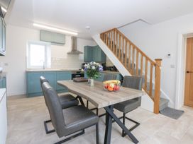 A kitchen with a dining table and chairs at Trefor Ganol in Beaumaris