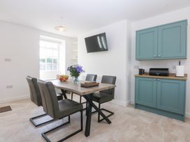 A dining room with a table and chairs at Trefor Ganol in Beaumaris