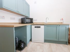 A kitchen with cabinets and appliances at Trefor Ganol Beaumaris