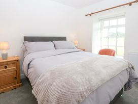 A bedroom with a bed and lamp at Trefor Ganol in Beaumaris