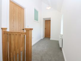 A hallway with wooden doors and a railing at Trefor Ganol Beaumaris