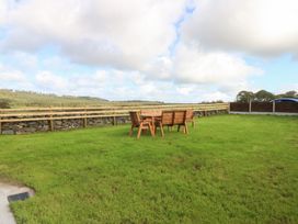 A garden with a table and chairs at Trefor Ganol in Beaumaris