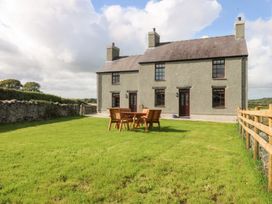 A house with a table and chairs in the outdoor area at Trefor Ganol Beaumaris