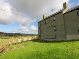 A building with a bench and grass at Trefor Ganol in Beaumaris