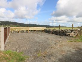 A gravel area enclosed by a stone wall and wooden fence at Trefor Ganol Beaumaris