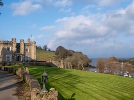 A castle with a lawn and trees at Watermouth Castle, West Tower Apartment in Ilfracombe