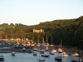 A view of boats on water with a castle in the background at Watermouth Castle, West Tower Apartment, Ilfracombe