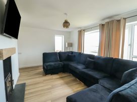 A living room with a sofa and television at 6 Gwelfor Estate