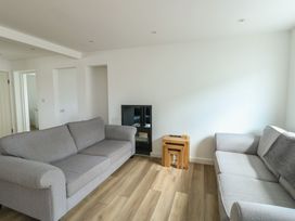 A living room with couches and a television at 6 Gwelfor Estate