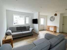 A living room with a sofa, table, and television at 6 Gwelfor Estate