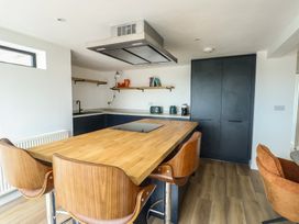 A kitchen with a central island and modern appliances at 6 Gwelfor Estate