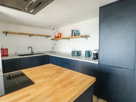 A kitchen with countertop, sink, and appliances at 6 Gwelfor Estate