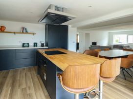 A kitchen with an island and dining area at 6 Gwelfor Estate