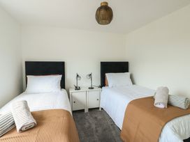 A bedroom with two single beds and a nightstand at 6 Gwelfor Estate