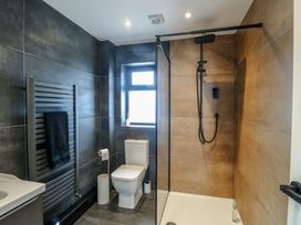 A bathroom with a shower, toilet, and sink at 6 Gwelfor Estate