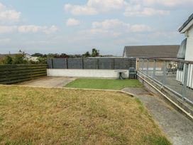 A garden with a patio and table at 6 Gwelfor Estate in 