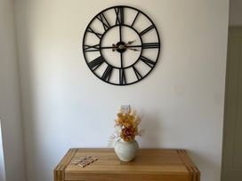 A console table with a vase and a clock at 6 Gwelfor Estate Cemaes Bay