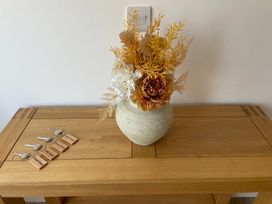 A vase with flowers on a wooden table at 6 Gwelfor Estate Cemaes Bay