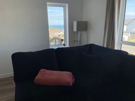 A living room with a sofa and a lamp at 6 Gwelfor Estate in Cemaes Bay