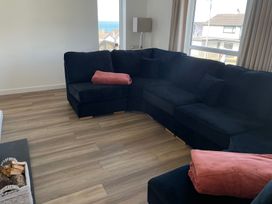 A living room with a sofa and a lamp at 6 Gwelfor Estate in Cemaes Bay