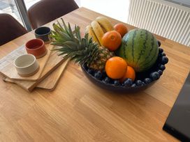 A kitchen with a fruit bowl on a wooden table at 6 Gwelfor Estate Cemaes Bay