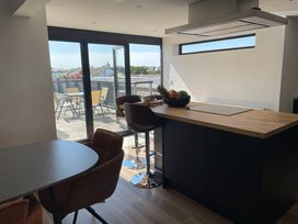 A kitchen with a dining area and access to an outdoor terrace at 6 Gwelfor Estate Cemaes Bay